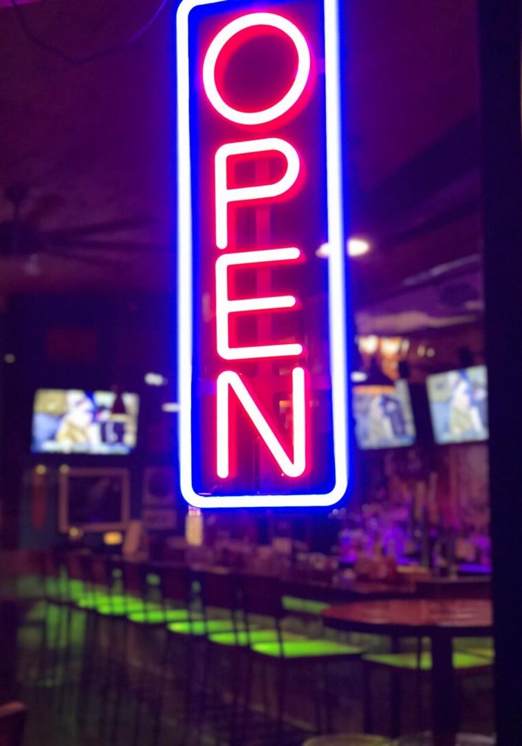 Illuminated bar interior with neon sign